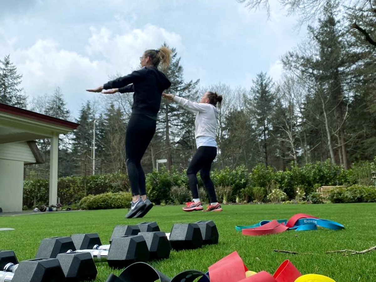 Twee mensen springen tegelijk omhoog op een grasveld