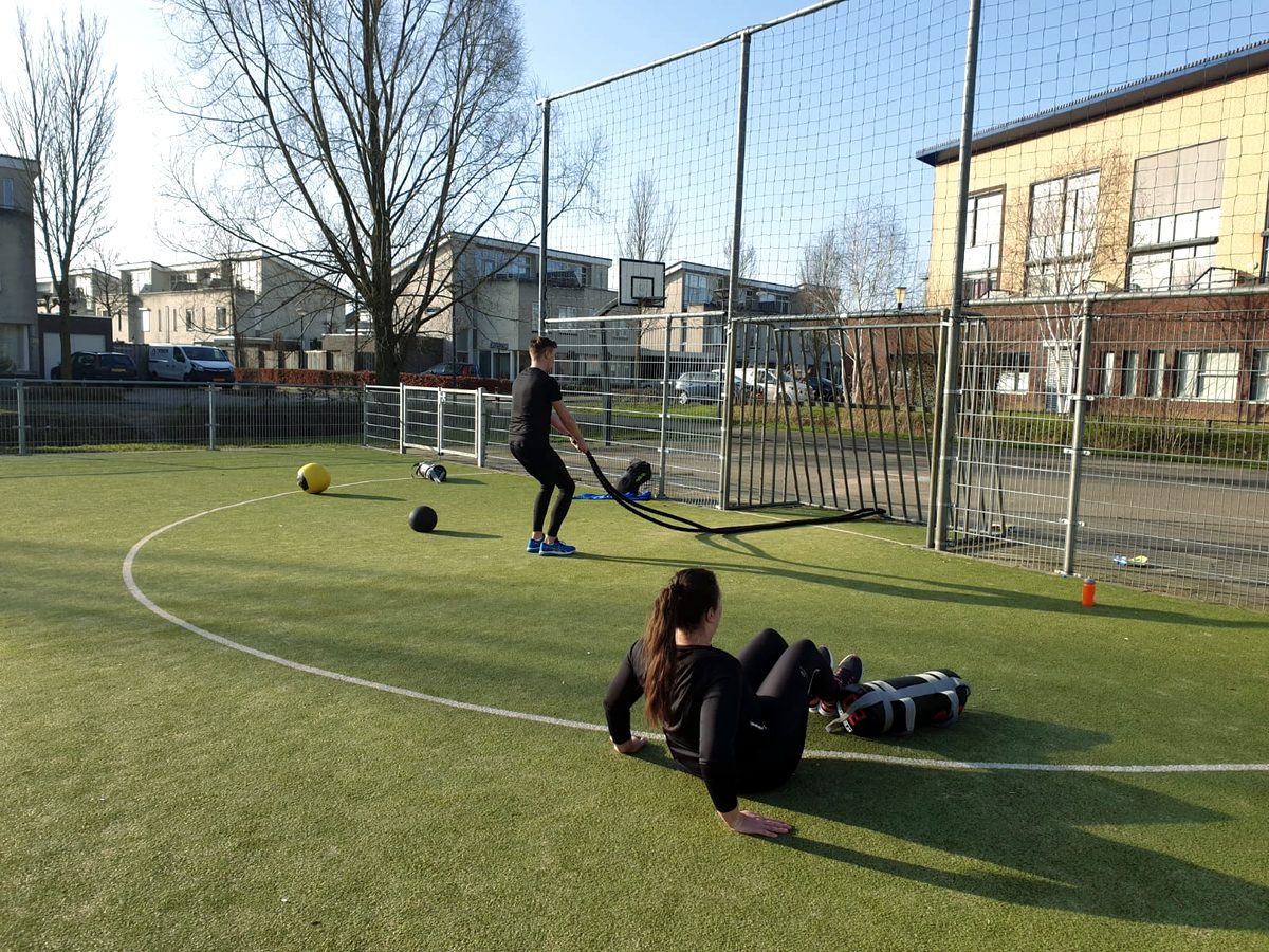 Twee mensen trainen op een kunstgrasveld